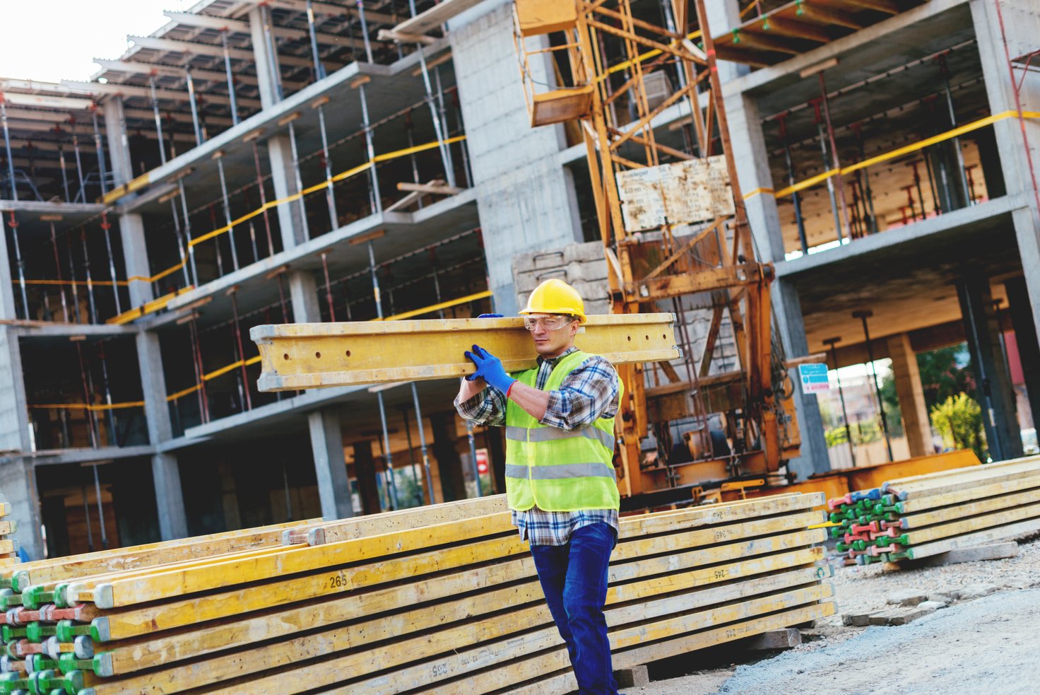 Construction worker working on construction platform, transferring construction material